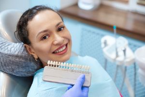 A Woman Smiles While Choosing Dental Veneers That Match Her Teeth