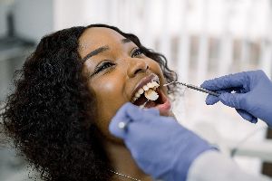 Person at the dentist's office, having their teeth examined by a dentist.