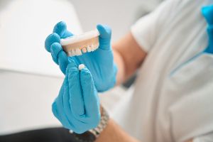 Dentist at the dentist's office showing dental crowns to a patient.