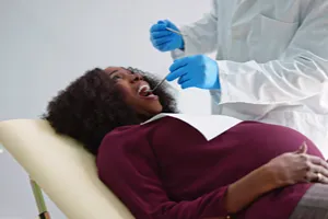 Person at the dentist's office, having their teeth worked on.