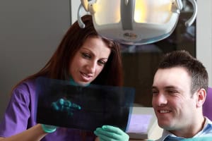 Person at dentist's office, reviewing the results of a dentist exam with the dentist.